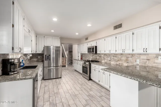 a stove top oven sitting inside of a kitchen