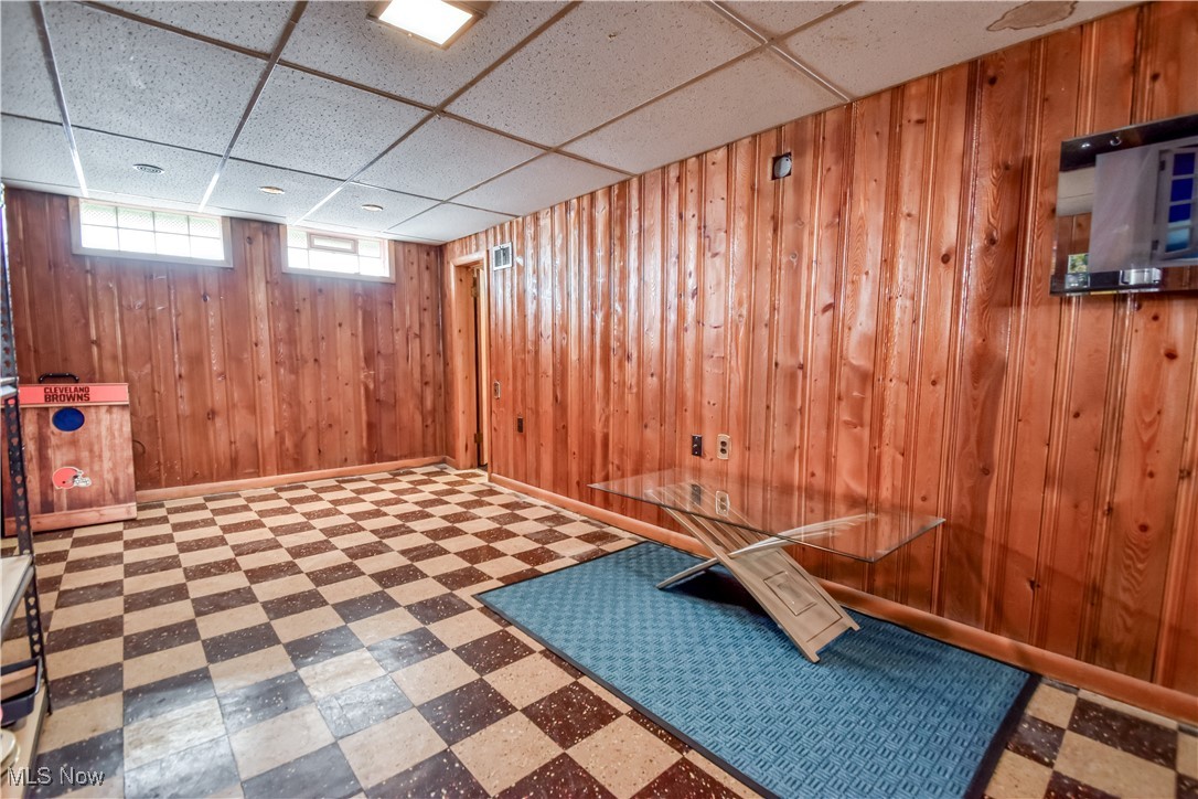 357 Clarmont Road Willowick, OH 44095 - Photo 20 of 27 Basement with tile patterned floors, a drop ceiling, and wooden walls