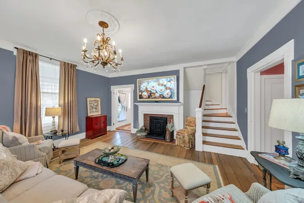 a living room with furniture a chandelier and a fireplace