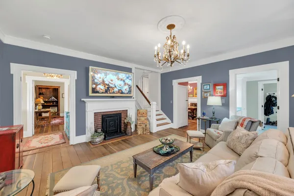 a living room with fireplace furniture and a chandelier