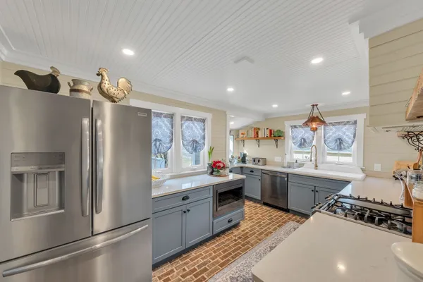 a kitchen with stainless steel appliances granite countertop a stove a sink dishwasher and cabinets with wooden floor
