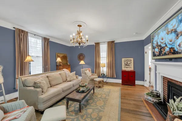 a living room with furniture a fireplace and a chandelier