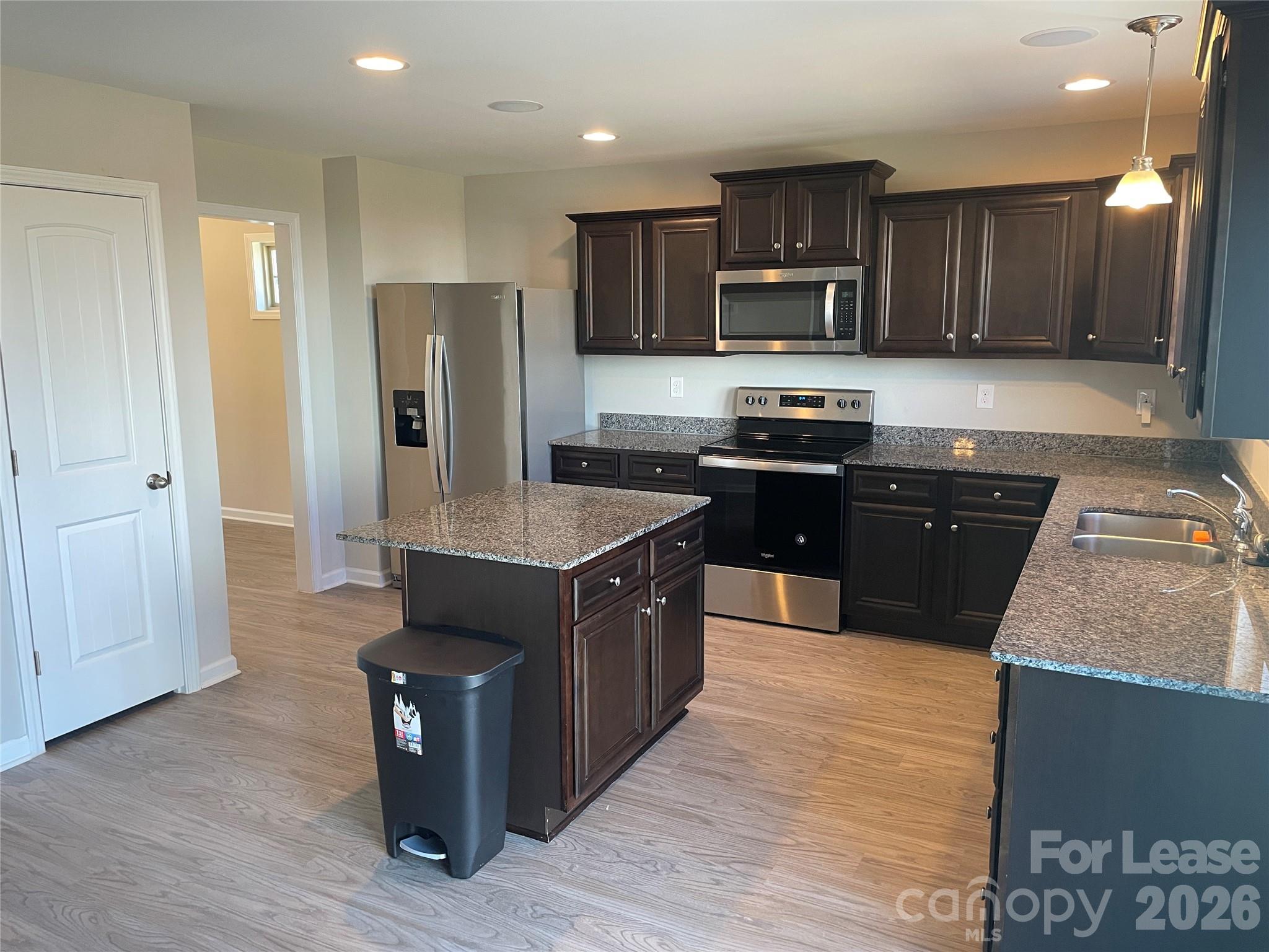 2909 Old Field Road Sumter, SC 29150 - Photo 7 of 39 a large kitchen with stainless steel appliances granite countertop a stove a sink dishwasher a refrigerator and a microwave oven with wooden cabinets