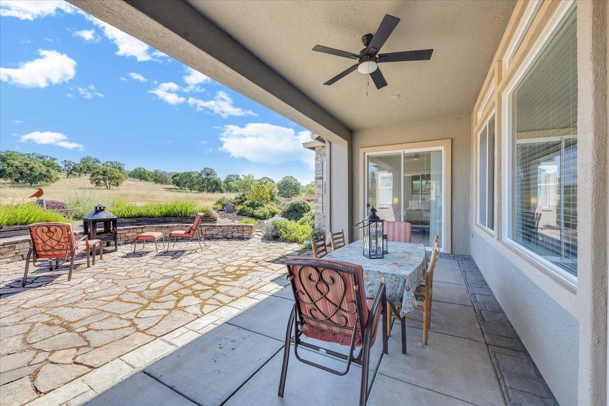 258 Rock Ridge Lane Copperopolis, CA 95228 - Photo 13 of 49 Covered patio, ceiling fan, flagstone extended patio. Rock Wall.