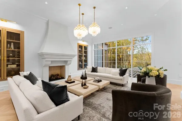 a living room with furniture a chandelier and a fireplace