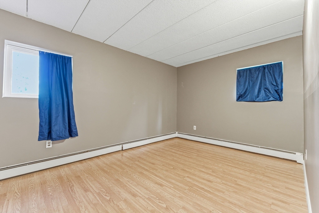 1011 Main Street, Unit 5 Woburn, MA 01801 - Photo 21 of 26 a view of an empty room with wooden floor and a window