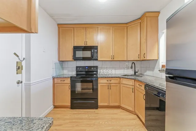 a kitchen with stainless steel appliances granite countertop a stove a sink and a refrigerator