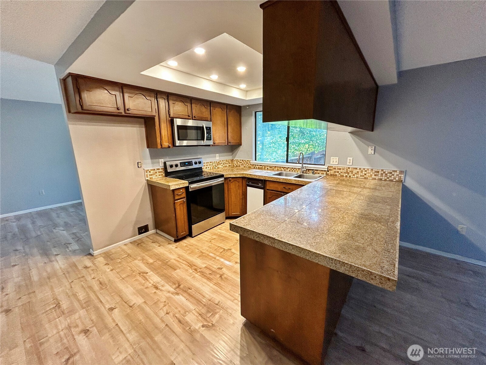 7305 38th Loop Southeast Lacey, WA 98503 - Photo 8 of 32 a kitchen with stainless steel appliances granite countertop a stove a sink and a refrigerator