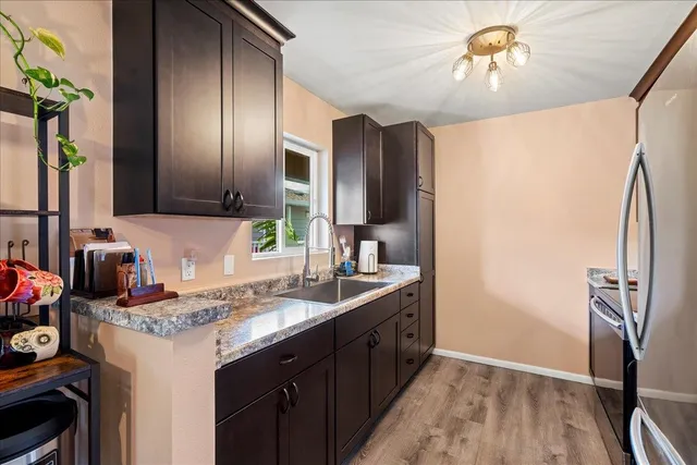 a kitchen with granite countertop a refrigerator stove and kitchen island