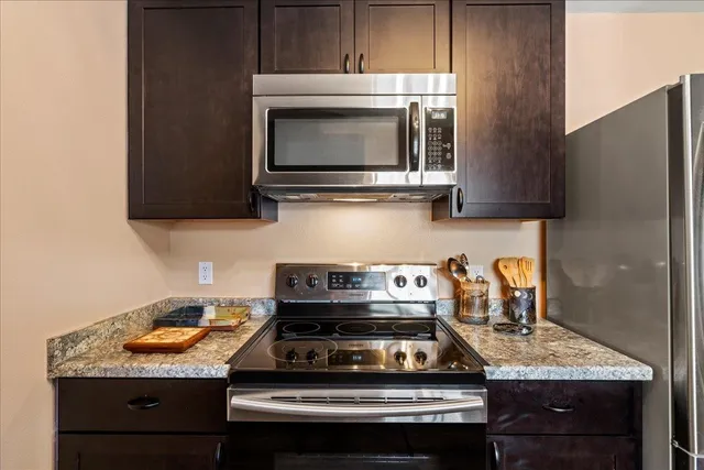 a kitchen with stainless steel appliances a stove a sink and a refrigerator