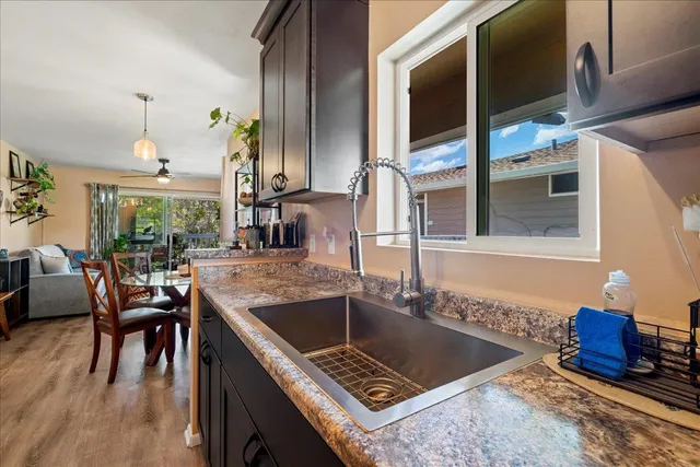 a kitchen with granite countertop a sink stove and refrigerator