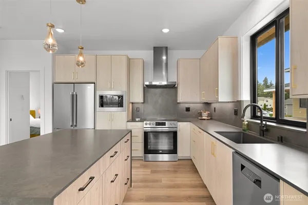 a kitchen with stainless steel appliances granite countertop a sink and a stove with white countertops