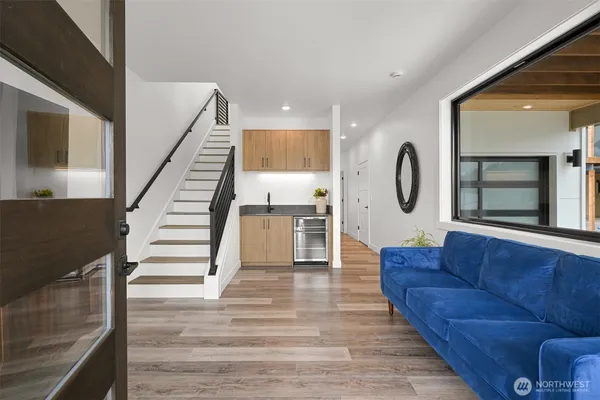 a living room with a couch and a dining table with wooden floor