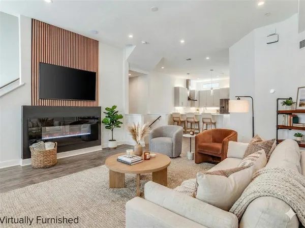 a living room with furniture a flat screen tv and a fireplace