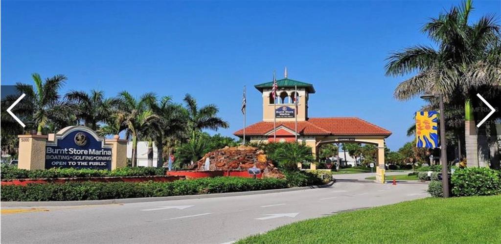 3181 Matecumbe Key Road, Unit 32 Punta Gorda, FL 33955 - Photo 37 of 42 a view of a house with a yard and table and chair under an umbrella