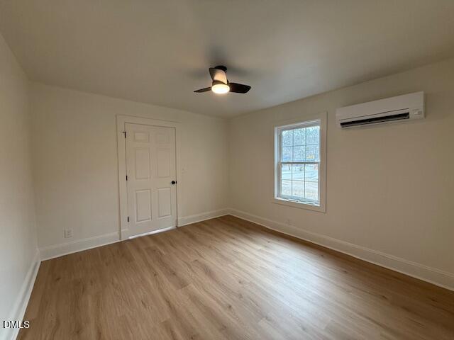 103 Broughton Street Garner, NC 27529 - Photo 13 of 15 an empty room with wooden floor ceiling fan and windows