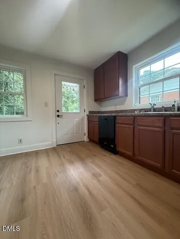 a large kitchen with wooden floors and sink