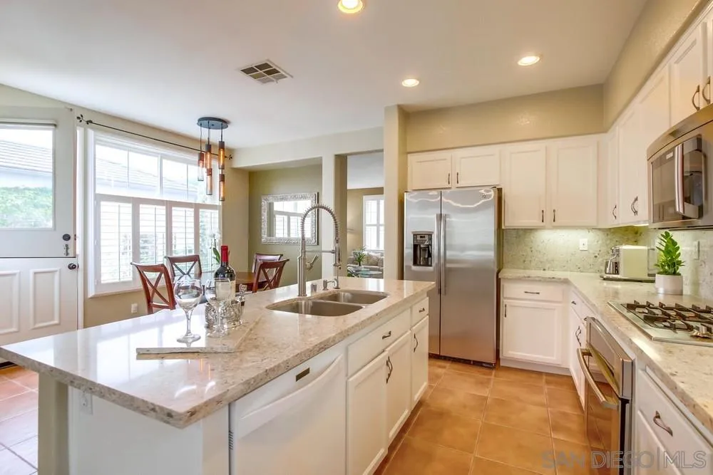 12237 Pepper Tree Lane Poway, CA 92064 - Photo 12 of 25 a kitchen with refrigerator and cabinets