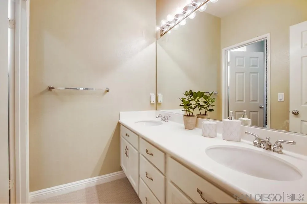 12237 Pepper Tree Lane Poway, CA 92064 - Photo 19 of 25 a bathroom with a double vanity sink and a mirror