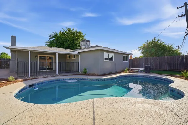 a view of a house with swimming pool and a yard