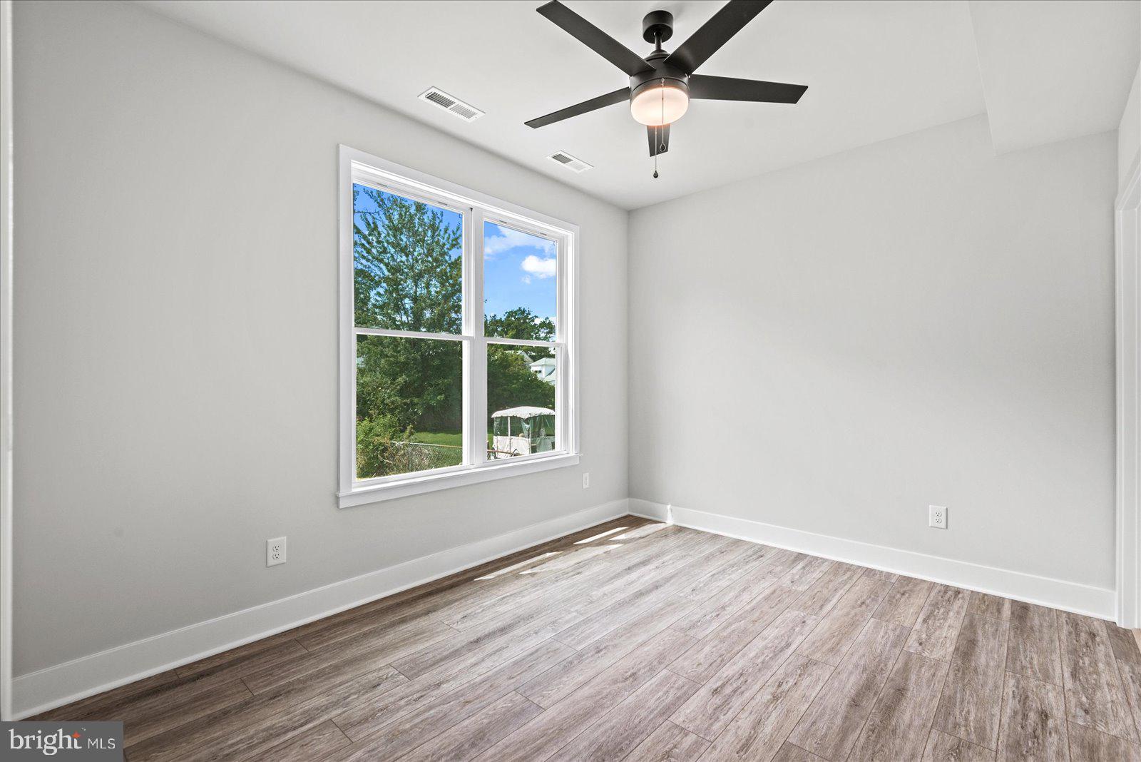 702 Taggart Street Colonial Beach, VA 22443 - Photo 17 of 64 an empty room with wooden floor fan and windows