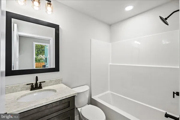 an empty room with wooden floor and ceiling fan