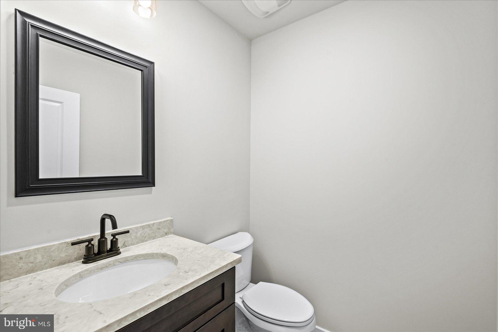 702 Taggart Street Colonial Beach, VA 22443 - Photo 20 of 64 a bathroom with a sink vanity mirror and toilet