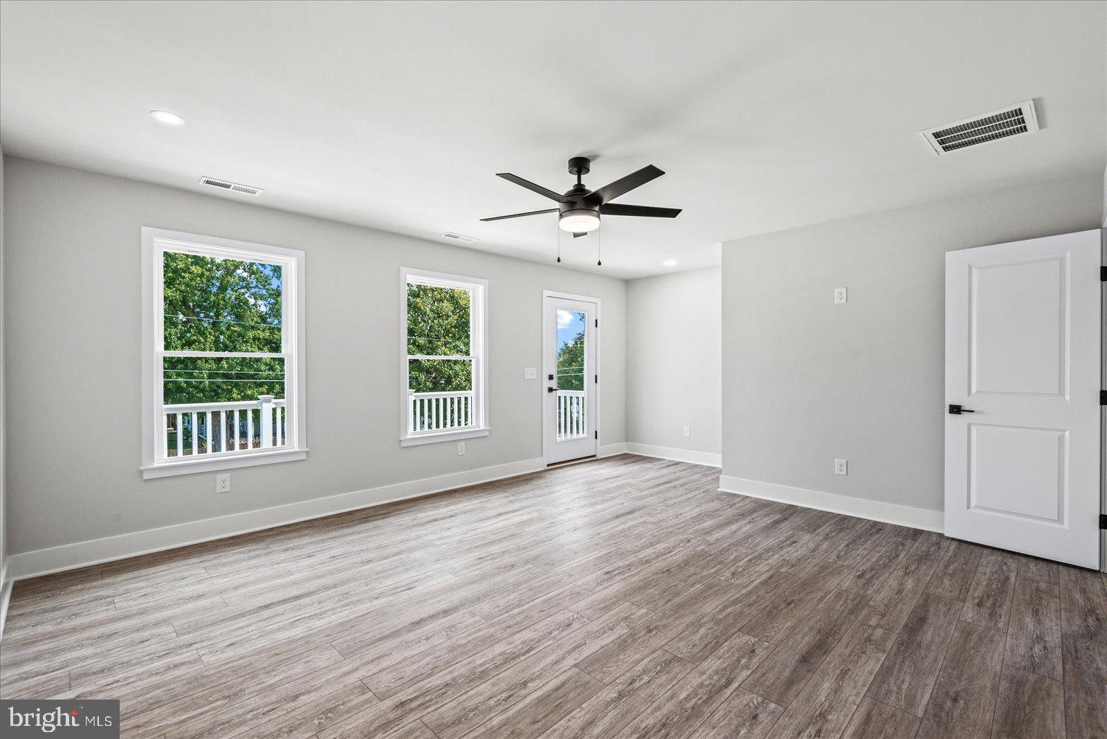 702 Taggart Street Colonial Beach, VA 22443 - Photo 23 of 64 a view of an empty room with a window and wooden floor