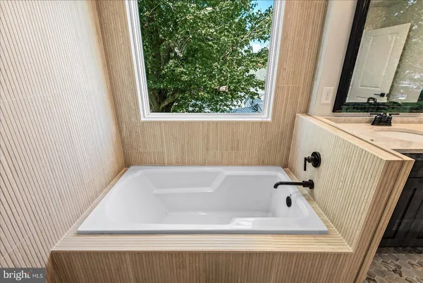 an empty room with wooden floor ceiling fan and windows