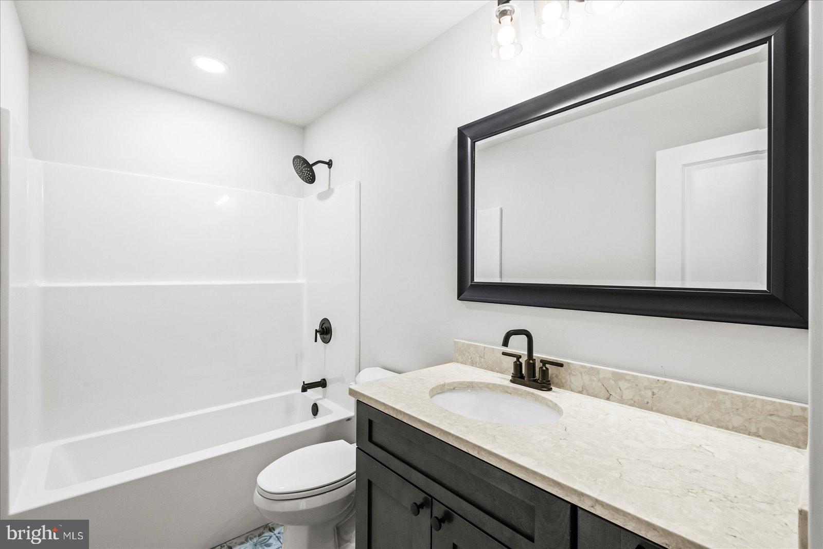 702 Taggart Street Colonial Beach, VA 22443 - Photo 37 of 64 a bathroom with a granite countertop sink a toilet and a bathtub