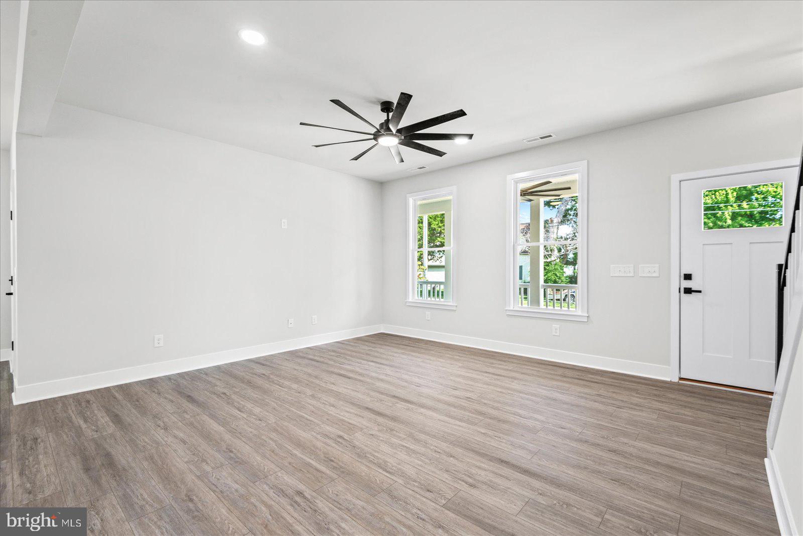702 Taggart Street Colonial Beach, VA 22443 - Photo 9 of 64 an empty room with wooden floor ceiling fan with window