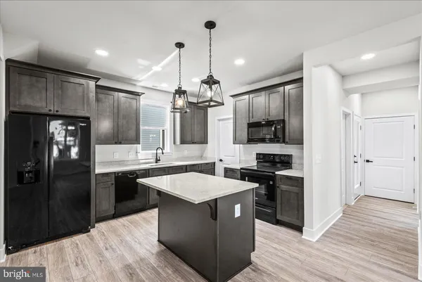 a kitchen that has a sink a stove and a wooden floor