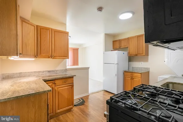 a kitchen with granite countertop a stove and a refrigerator