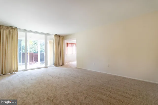 a view of a big room with windows and chandelier fan