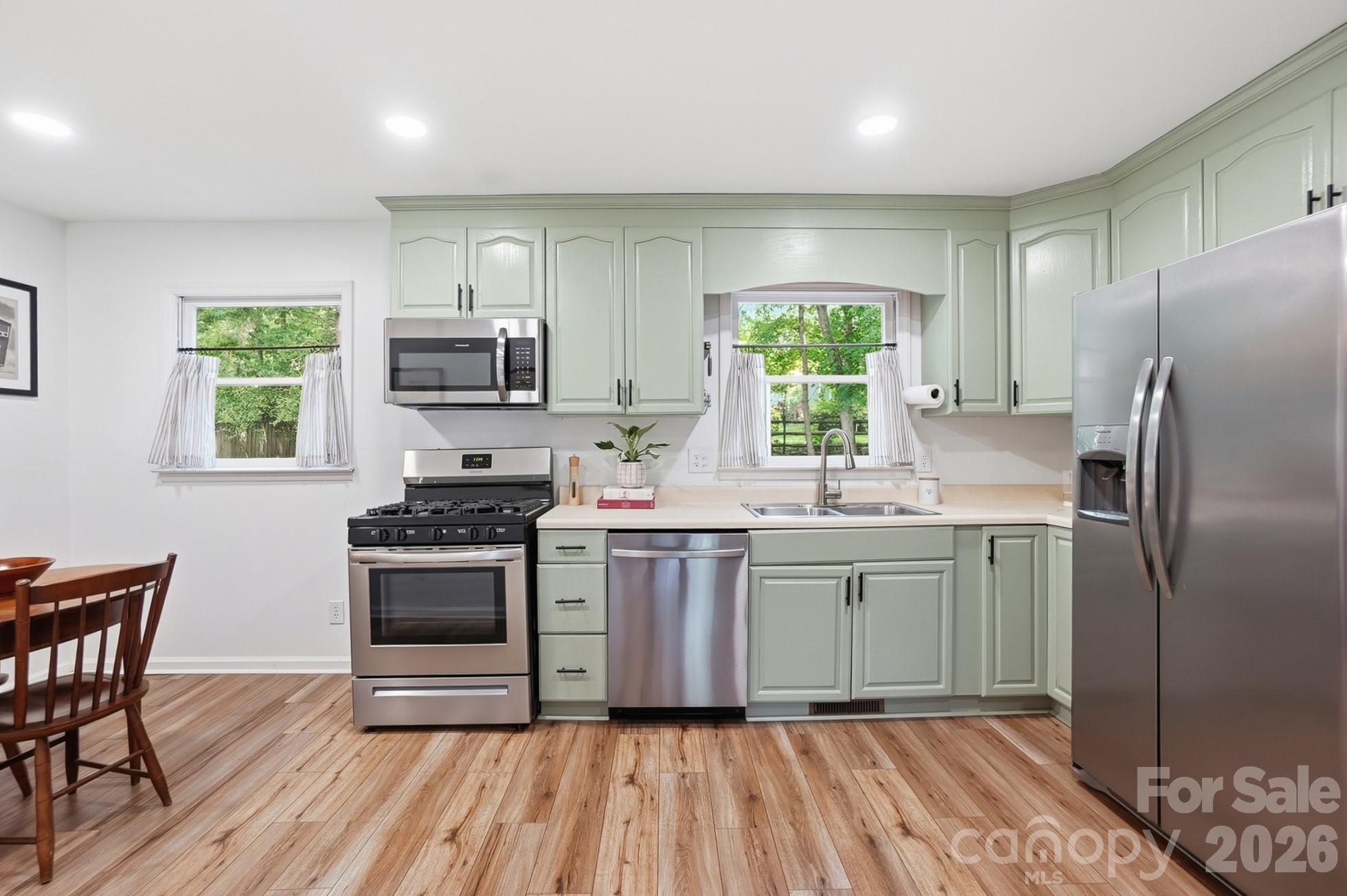 5060 Suwarrow Circle Tega Cay, SC 29708 - Photo 7 of 34 a kitchen with kitchen island granite countertop a stove a sink and a refrigerator
