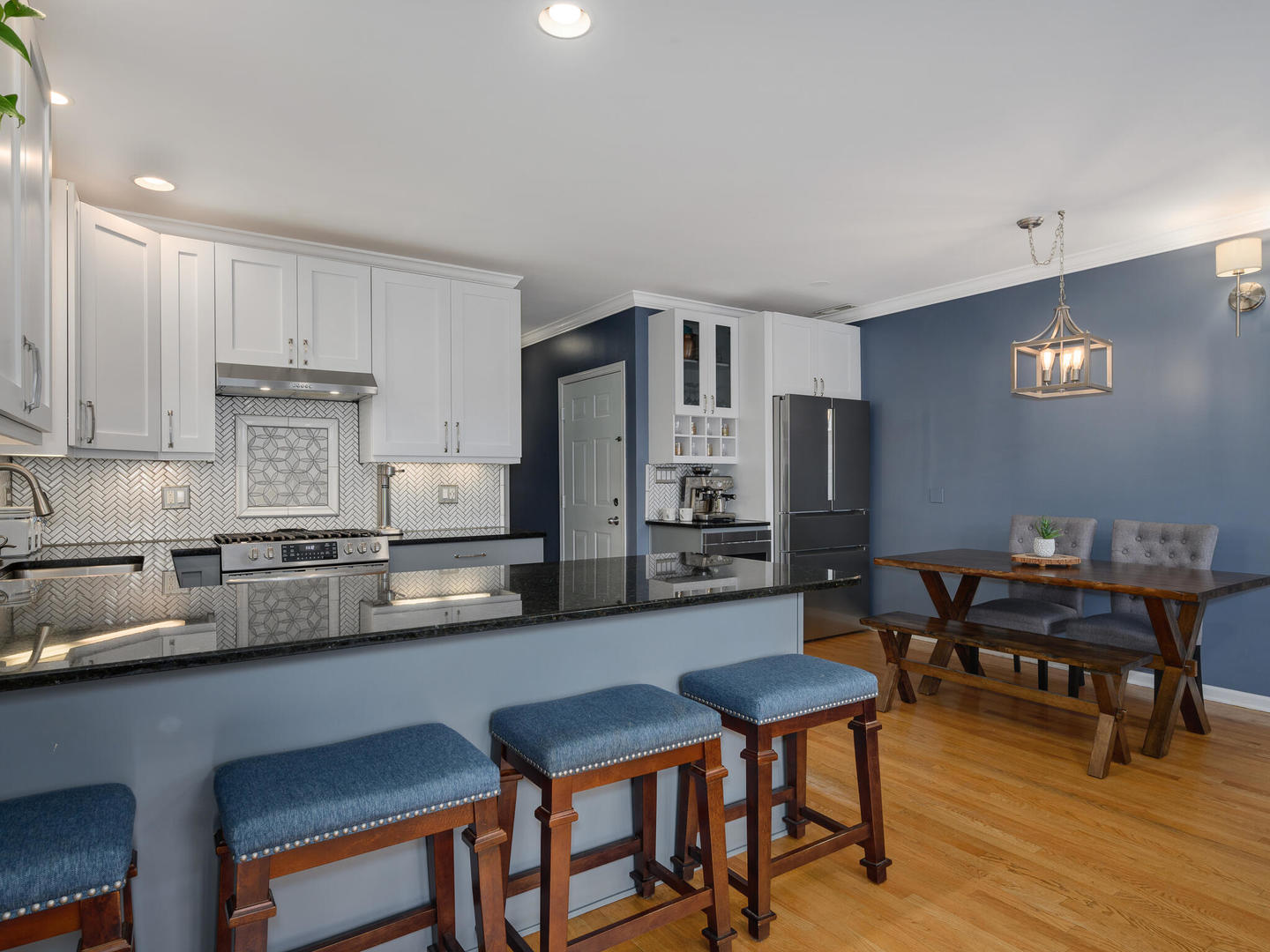 1012 North Wood Street, Unit 2 Chicago, IL 60622 - Photo 7 of 21 a kitchen with stainless steel appliances kitchen island granite countertop a dining table chairs and a refrigerator