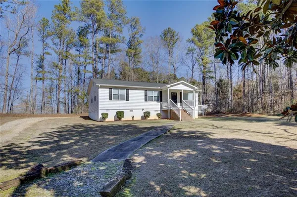 a front view of a house with a dirt yard and a garage