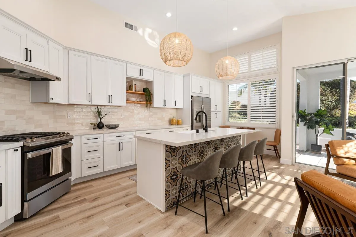 a kitchen with a dining table chairs stainless steel appliances and cabinets