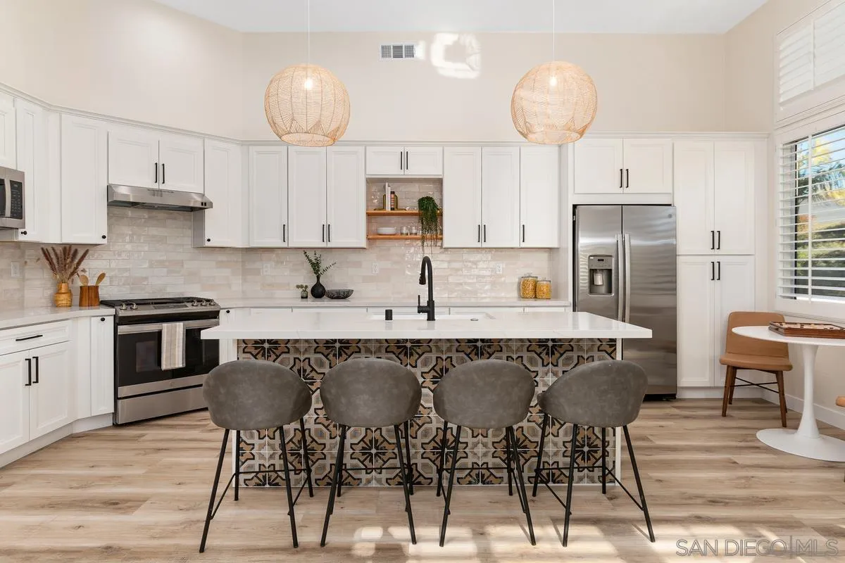 6027 Dassia Way Oceanside, CA 92056 - Photo 17 of 45 a kitchen with stainless steel appliances granite countertop a sink a stove a refrigerator cabinets and chairs