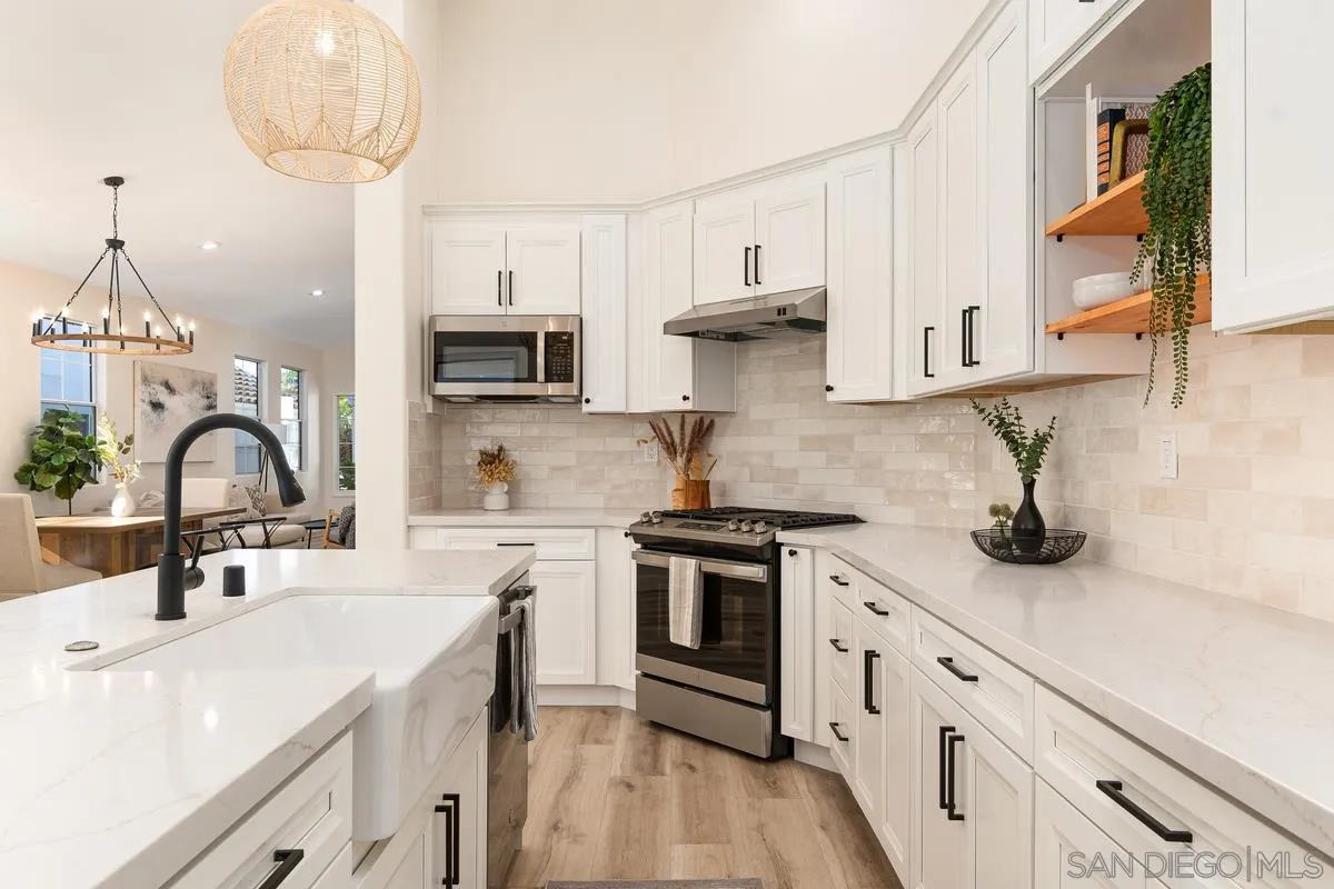 6027 Dassia Way Oceanside, CA 92056 - Photo 18 of 45 a kitchen with stainless steel appliances a sink stove and cabinets