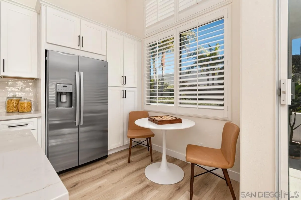 6027 Dassia Way Oceanside, CA 92056 - Photo 19 of 45 a kitchen with stainless steel appliances granite countertop a table chairs and a refrigerator