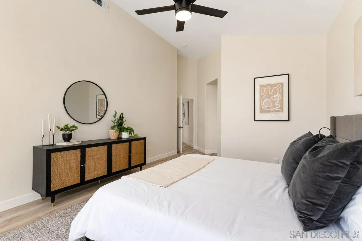 6027 Dassia Way Oceanside, CA 92056 - Photo 21 of 45 a bedroom with a bed a mirror and a window