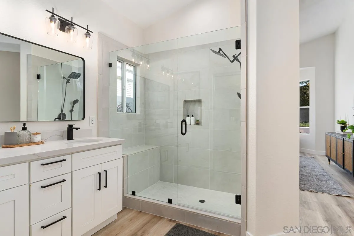 6027 Dassia Way Oceanside, CA 92056 - Photo 23 of 45 a bathroom with a shower sink and mirror