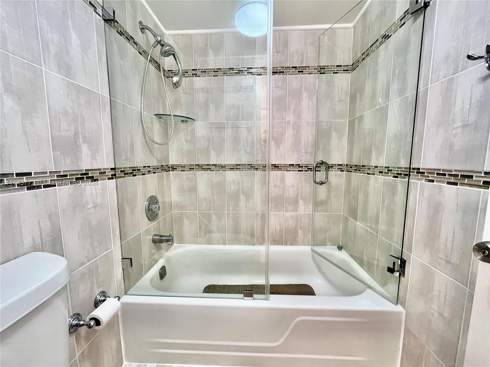 9273 Collins Avenue, Unit 507 Surfside, FL 33154 - Photo 15 of 28 a bathroom with a shower and a bathtub