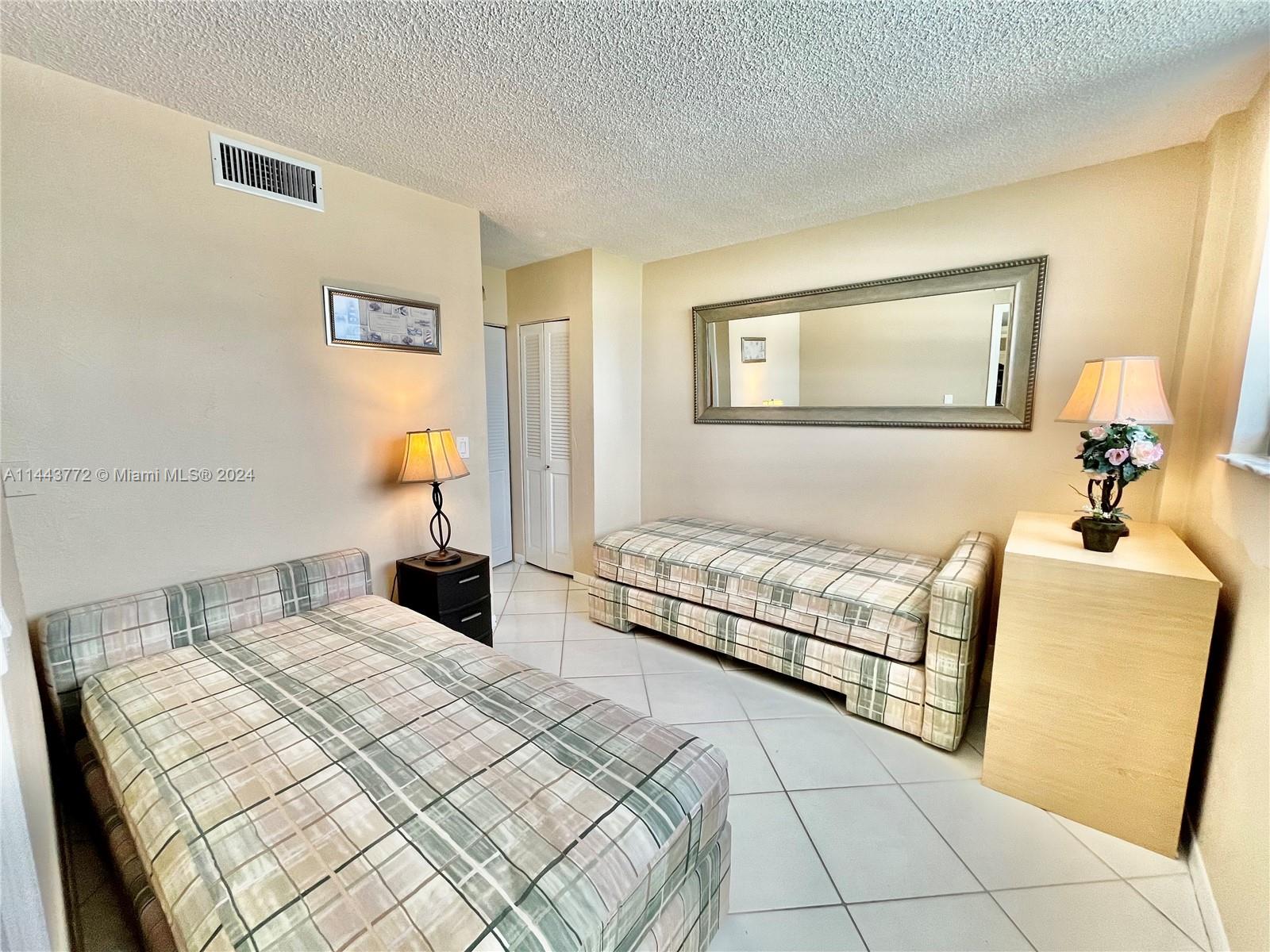 9273 Collins Avenue, Unit 507 Surfside, FL 33154 - Photo 17 of 28 a bedroom with a bed and a couch