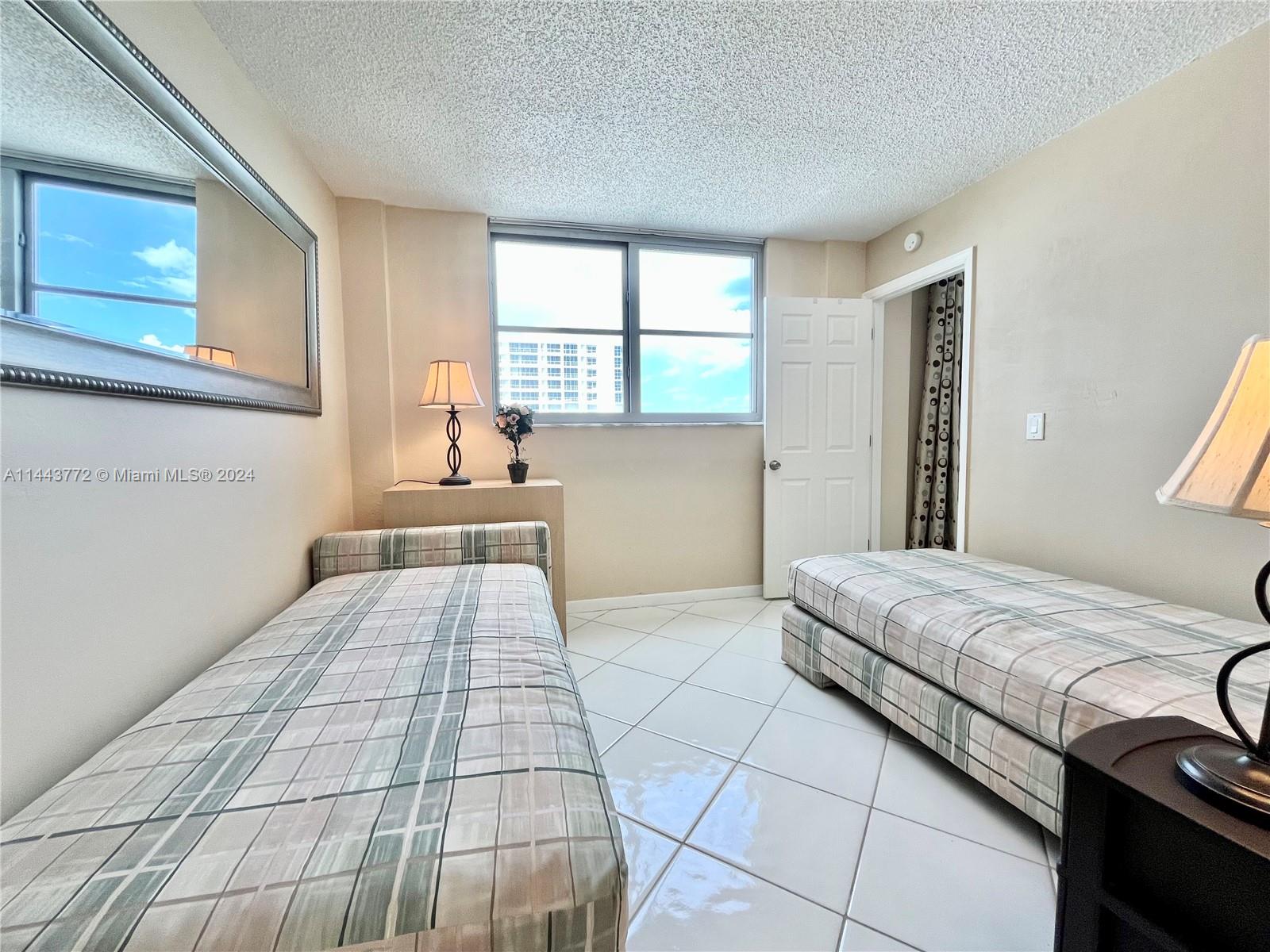 9273 Collins Avenue, Unit 507 Surfside, FL 33154 - Photo 18 of 28 a bedroom with a bed and a window