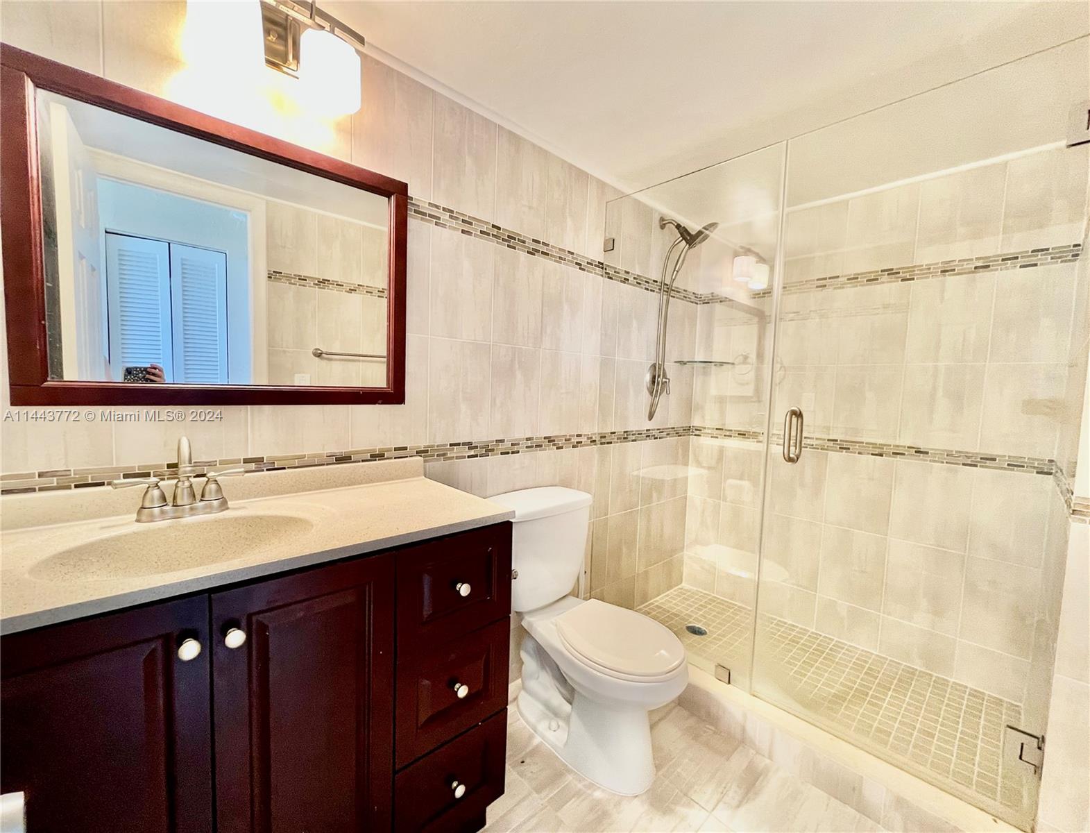 9273 Collins Avenue, Unit 507 Surfside, FL 33154 - Photo 19 of 28 a bathroom with a sink a toilet and shower
