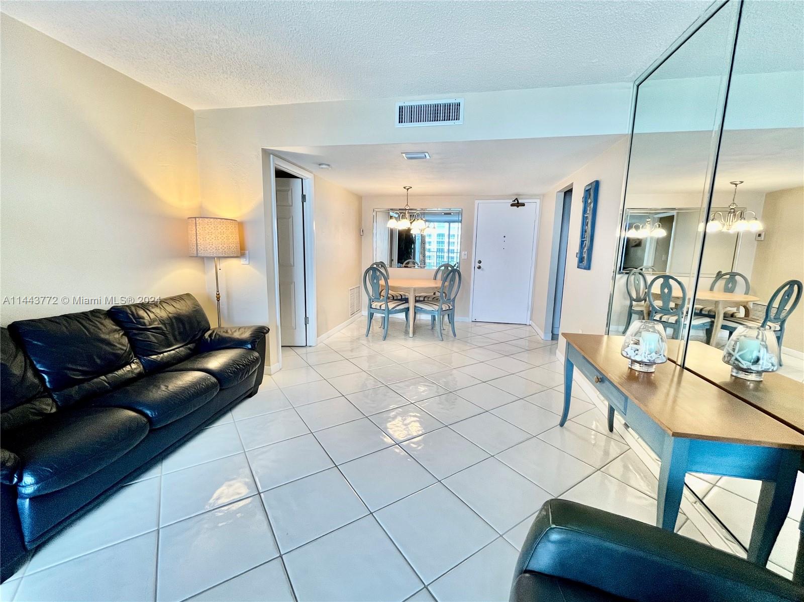 9273 Collins Avenue, Unit 507 Surfside, FL 33154 - Photo 21 of 28 a living room with furniture a table and chairs