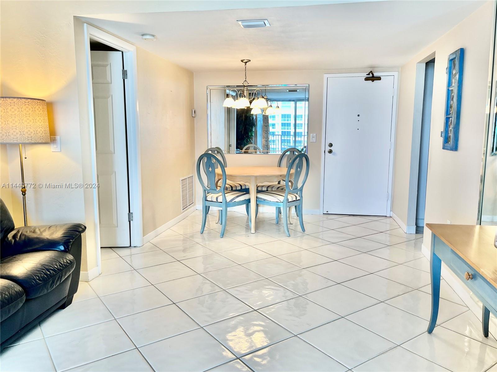 9273 Collins Avenue, Unit 507 Surfside, FL 33154 - Photo 8 of 28 a dining room with furniture and a chandelier