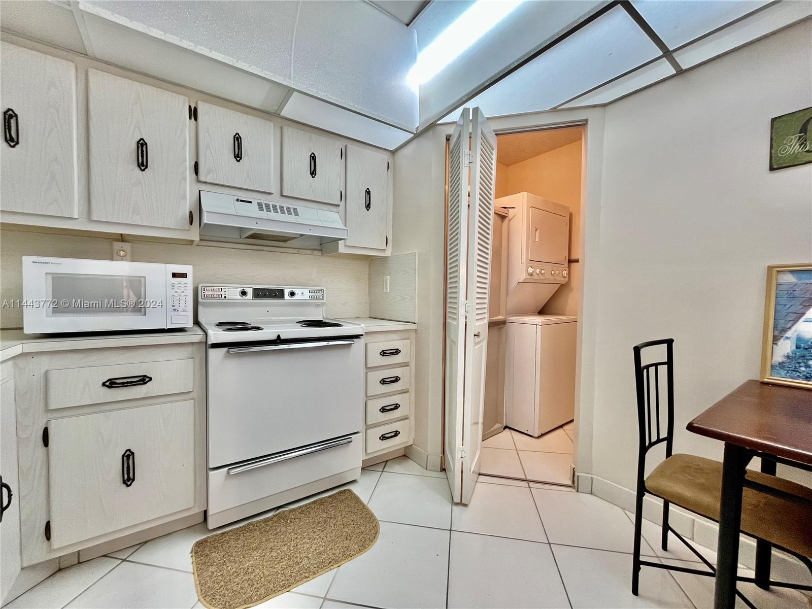 9273 Collins Avenue, Unit 507 Surfside, FL 33154 - Photo 9 of 28 a kitchen with stainless steel appliances granite countertop a refrigerator sink and cabinets